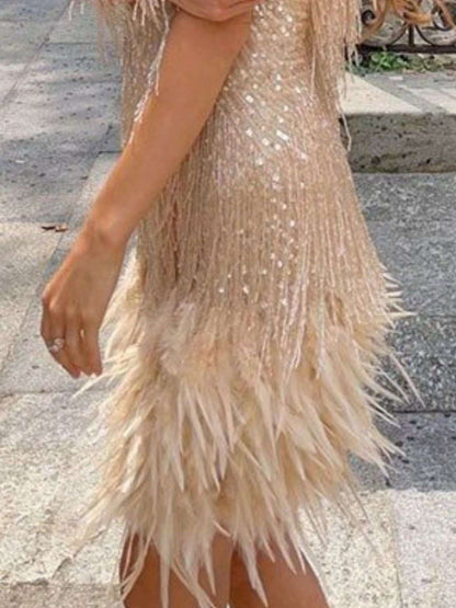 Beige sequin dress with feather details on a stone pavement background