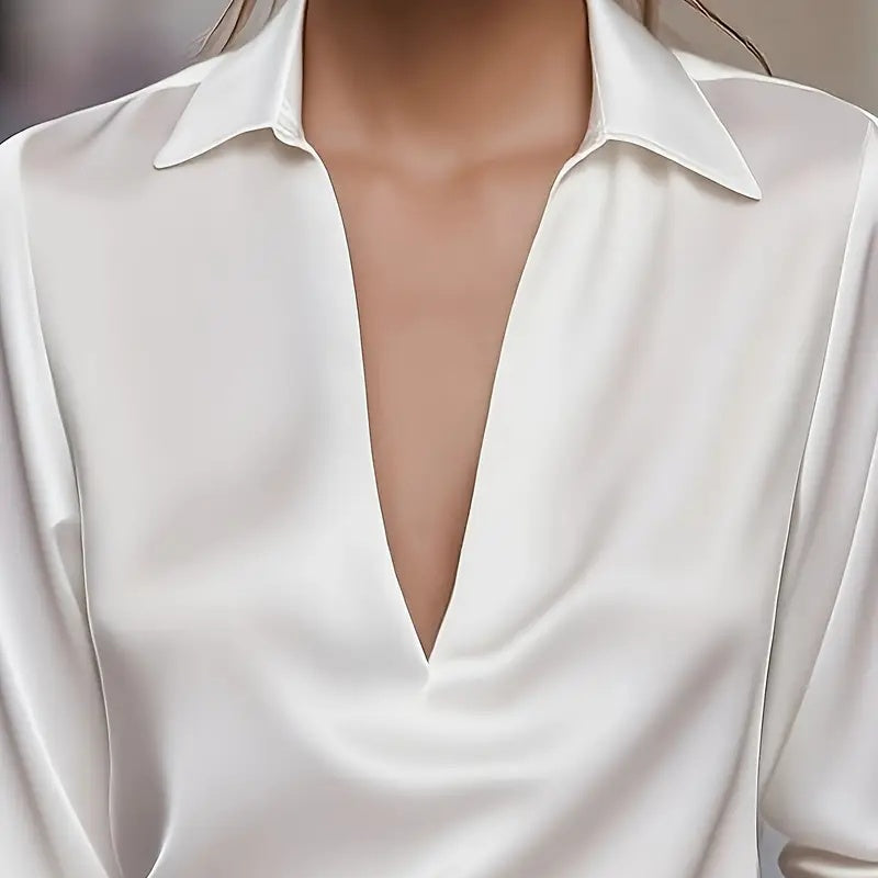 White blouse with a deep neckline on a neutral background