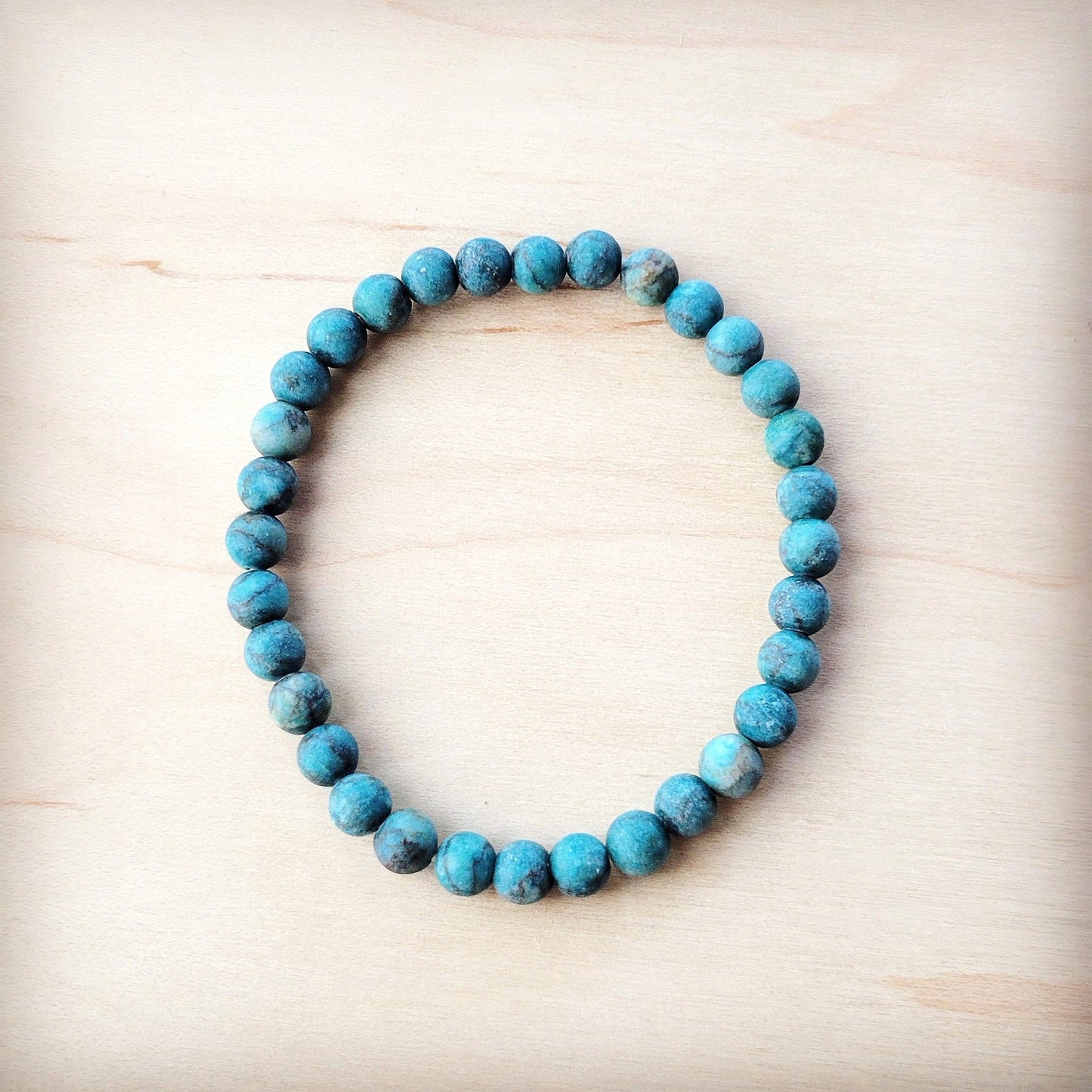 Turquoise beaded bracelet on a light wooden surface