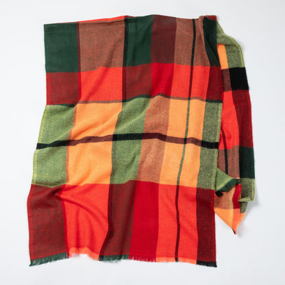 Plaid blanket with red, green, and orange colors on a white background