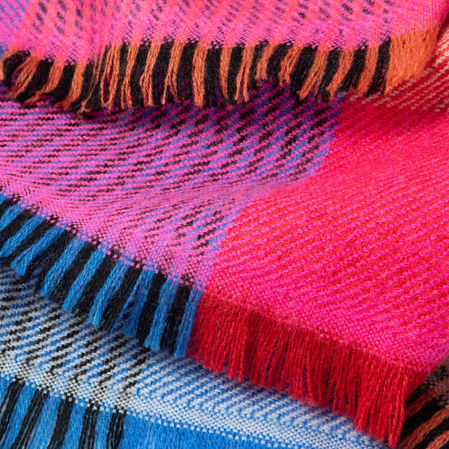 Close-up of a colorful woven fabric with pink, blue, and orange patterns.