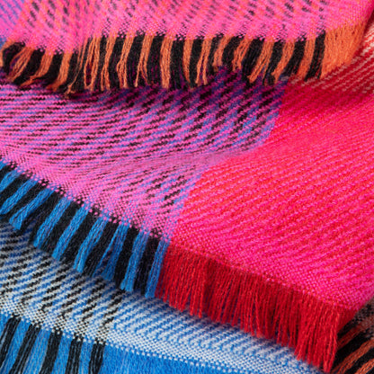 Close-up of a colorful woven fabric with pink, blue, and orange patterns.