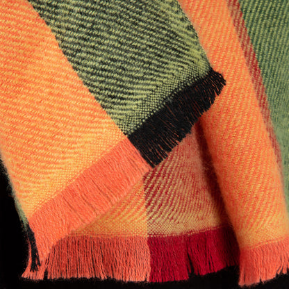 Close-up of a colorful plaid fabric with orange, green, and red patterns.