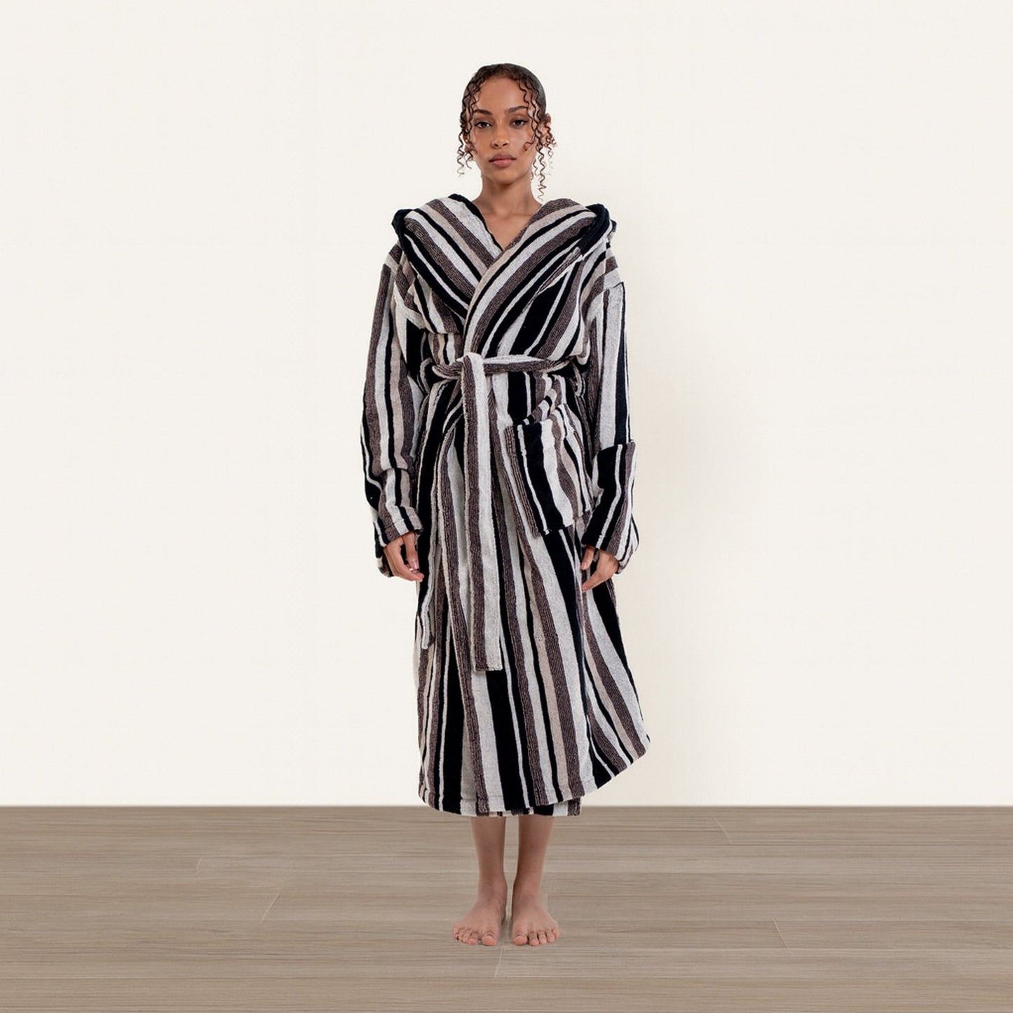 Woman wearing a black and white striped robe on a plain background