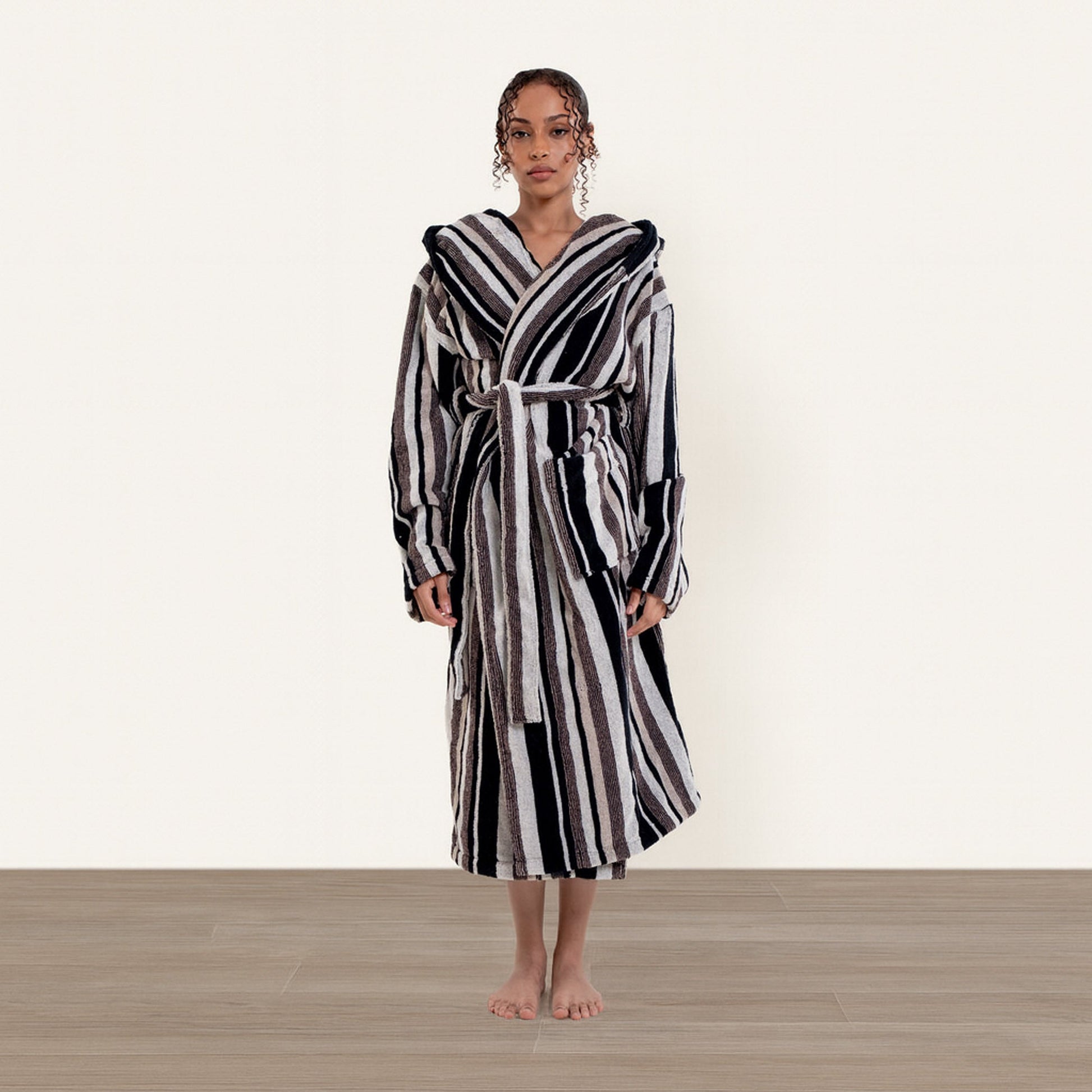 Woman wearing a black and white striped robe on a plain background