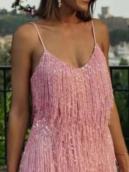 Woman wearing a pink sequin dress with a blurred outdoor background