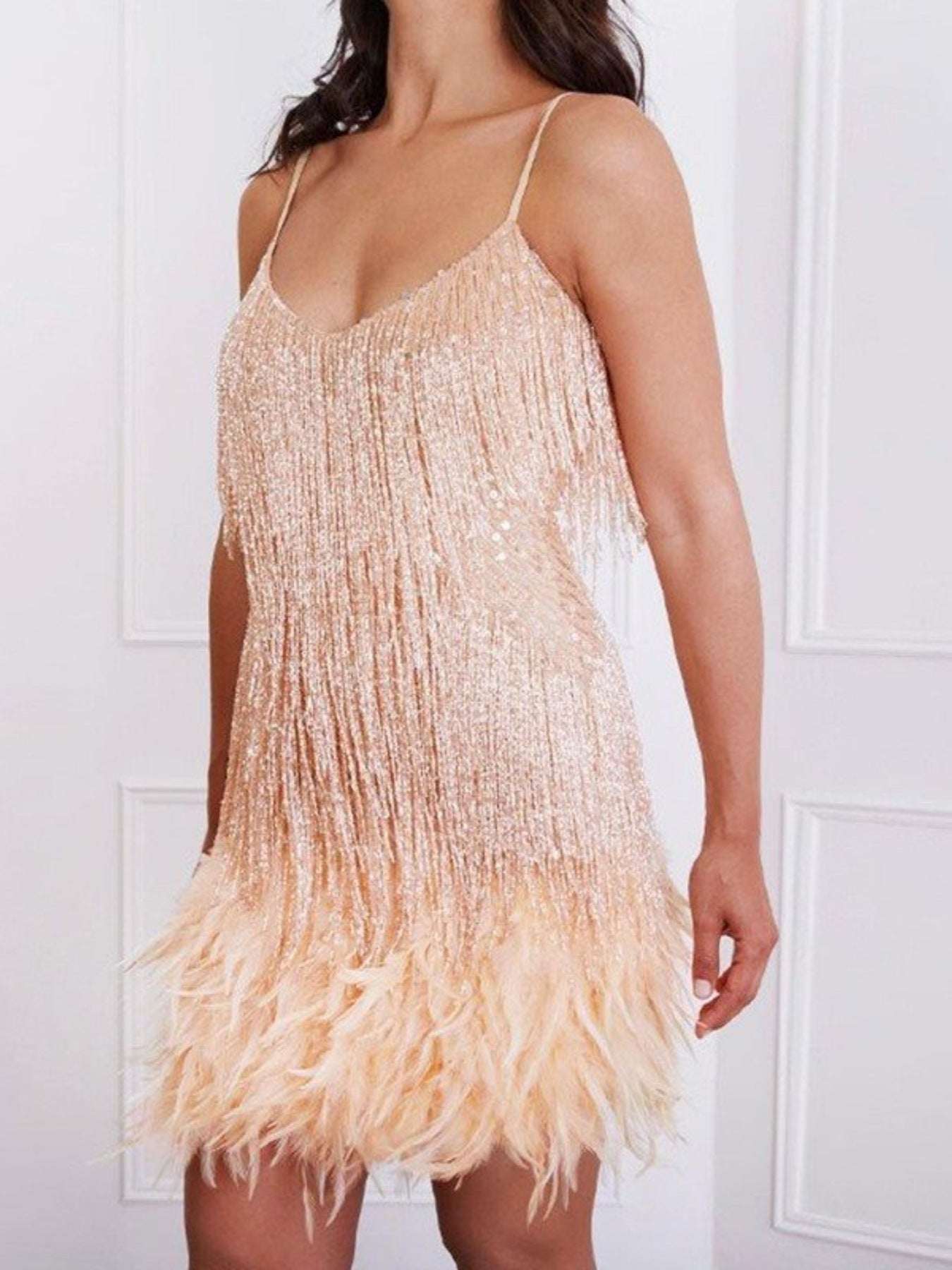 Beige fringe dress worn by a person against a white background