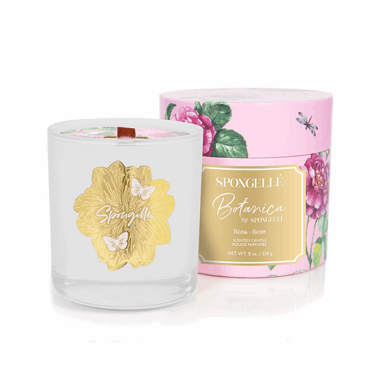 Rose botanica candle in a clear glass jar with a gold floral design, surrounded by a pink floral box.