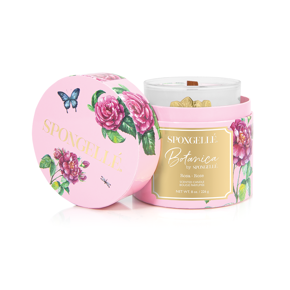 Rose botanica candle in a pink floral box with gold accents and a butterfly design, featuring a clear glass container.
