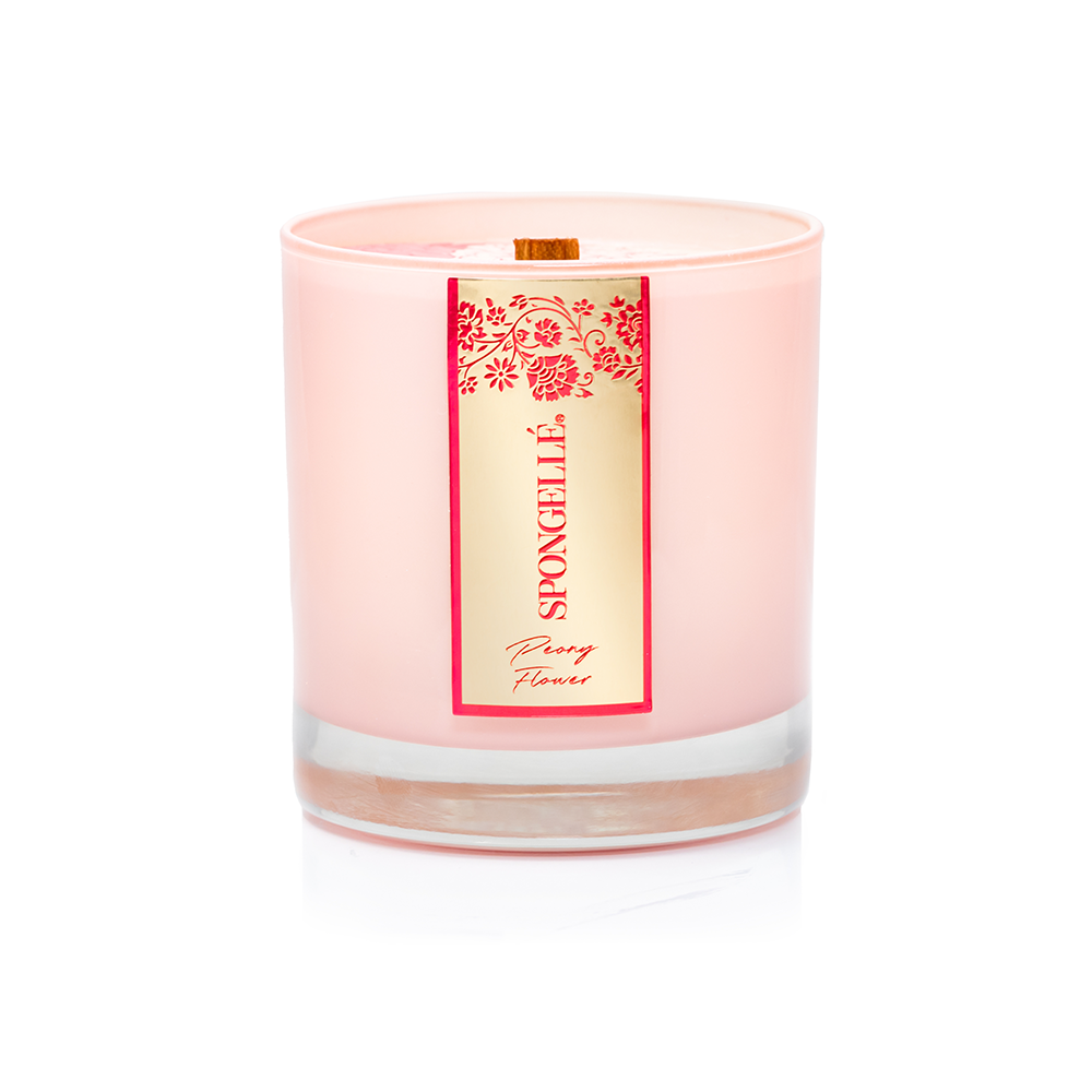 Peony Flower Private Reserve candle in a pink glass container with a wooden wick and decorative label.