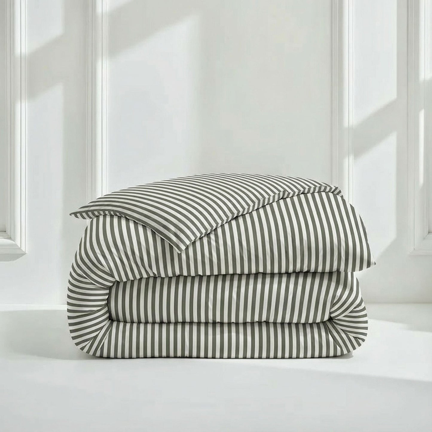 Stack of striped bedding on a white surface with a neutral background
