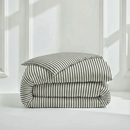 Stack of striped bedding on a white surface with a neutral background