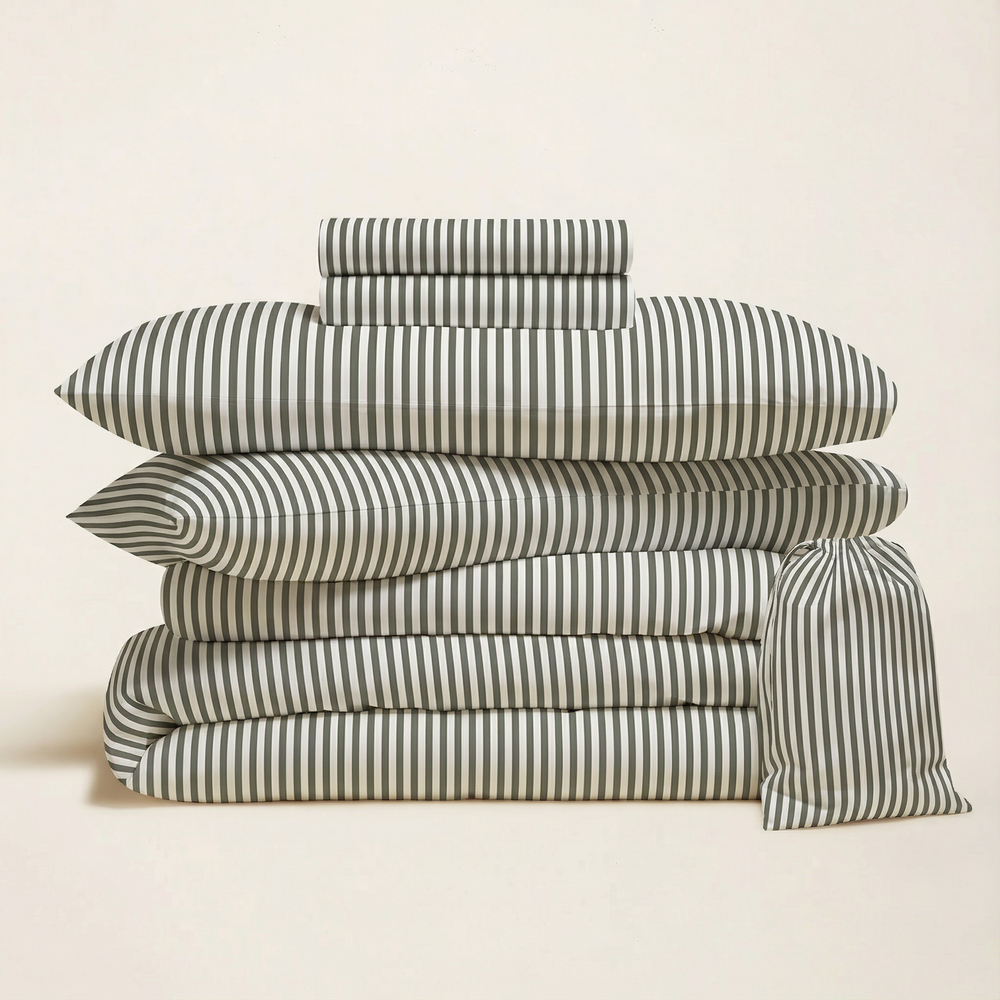 Stack of striped bed sheets and pillowcases on a beige background