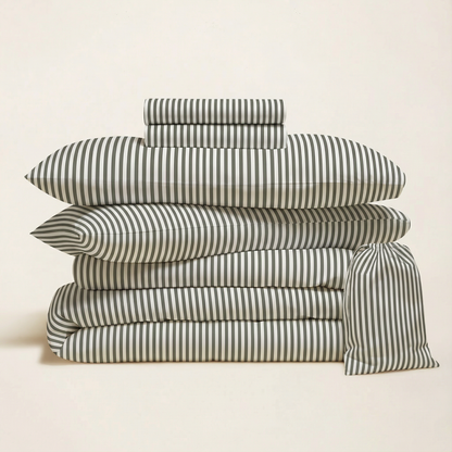 Stack of striped bed sheets and pillowcases on a beige background