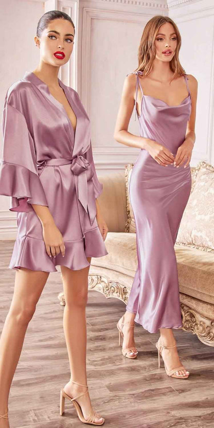Two women in lavender satin outfits standing in a stylish room.