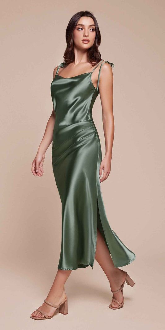 Woman wearing a green satin dress on a beige background