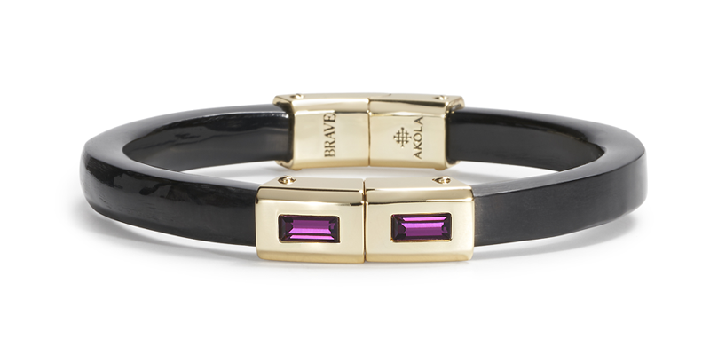 Black and gold bracelet with purple gemstones on a white background