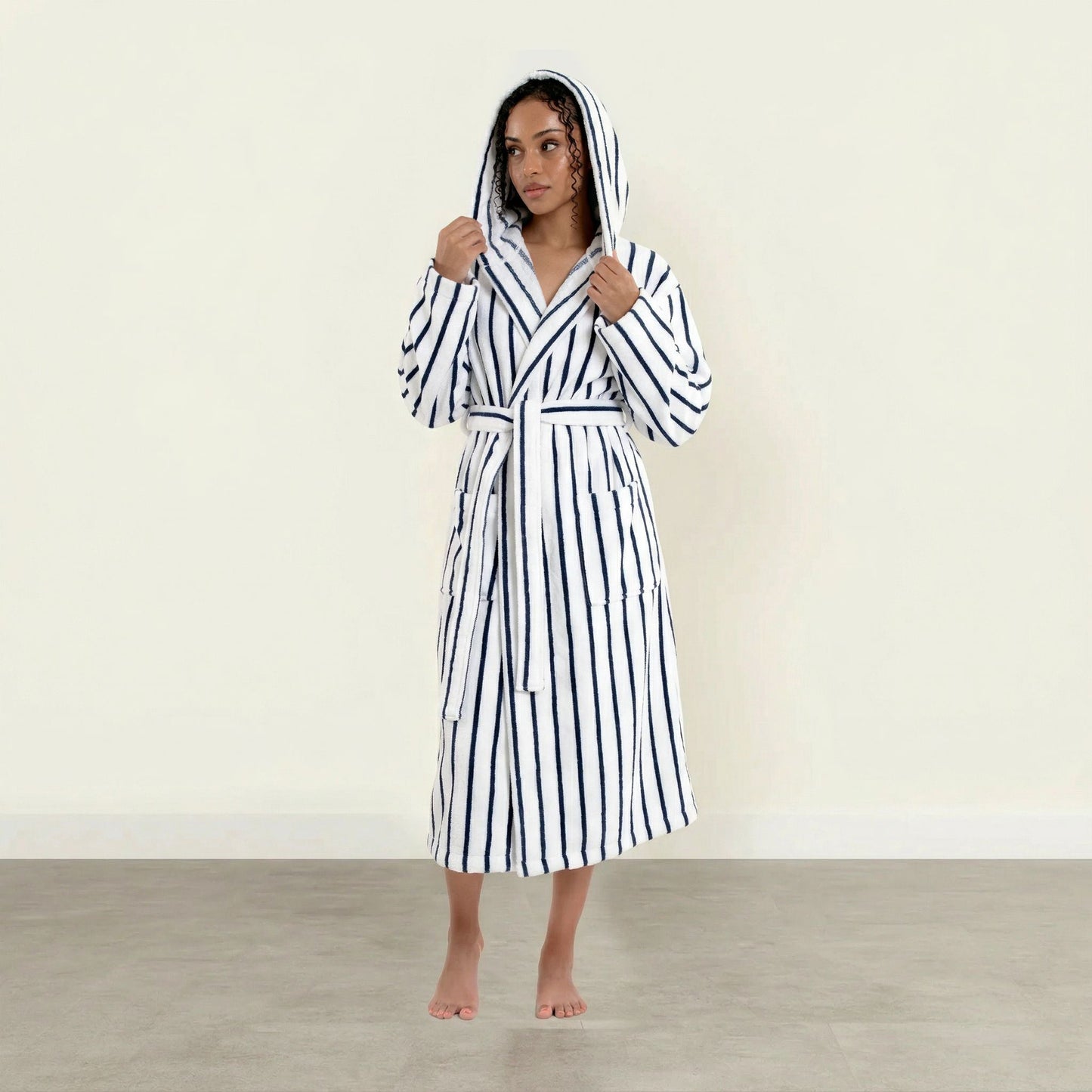 Woman wearing a black and white striped robe on a plain background