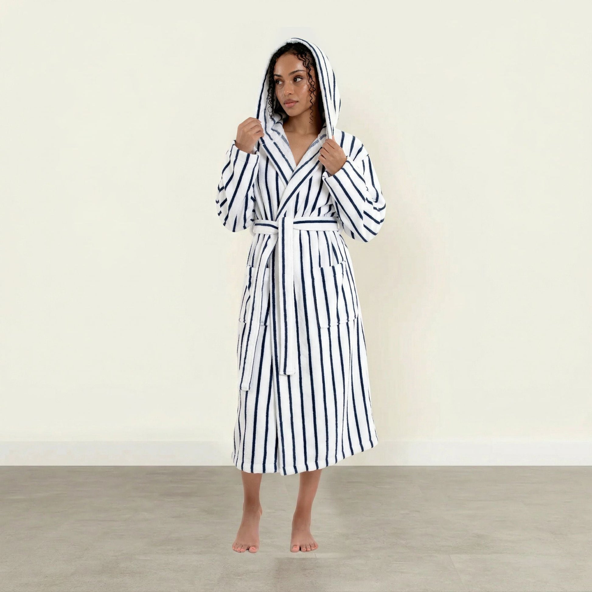 Woman wearing a black and white striped robe on a plain background