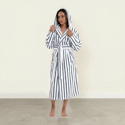 Woman wearing a black and white striped robe on a plain background