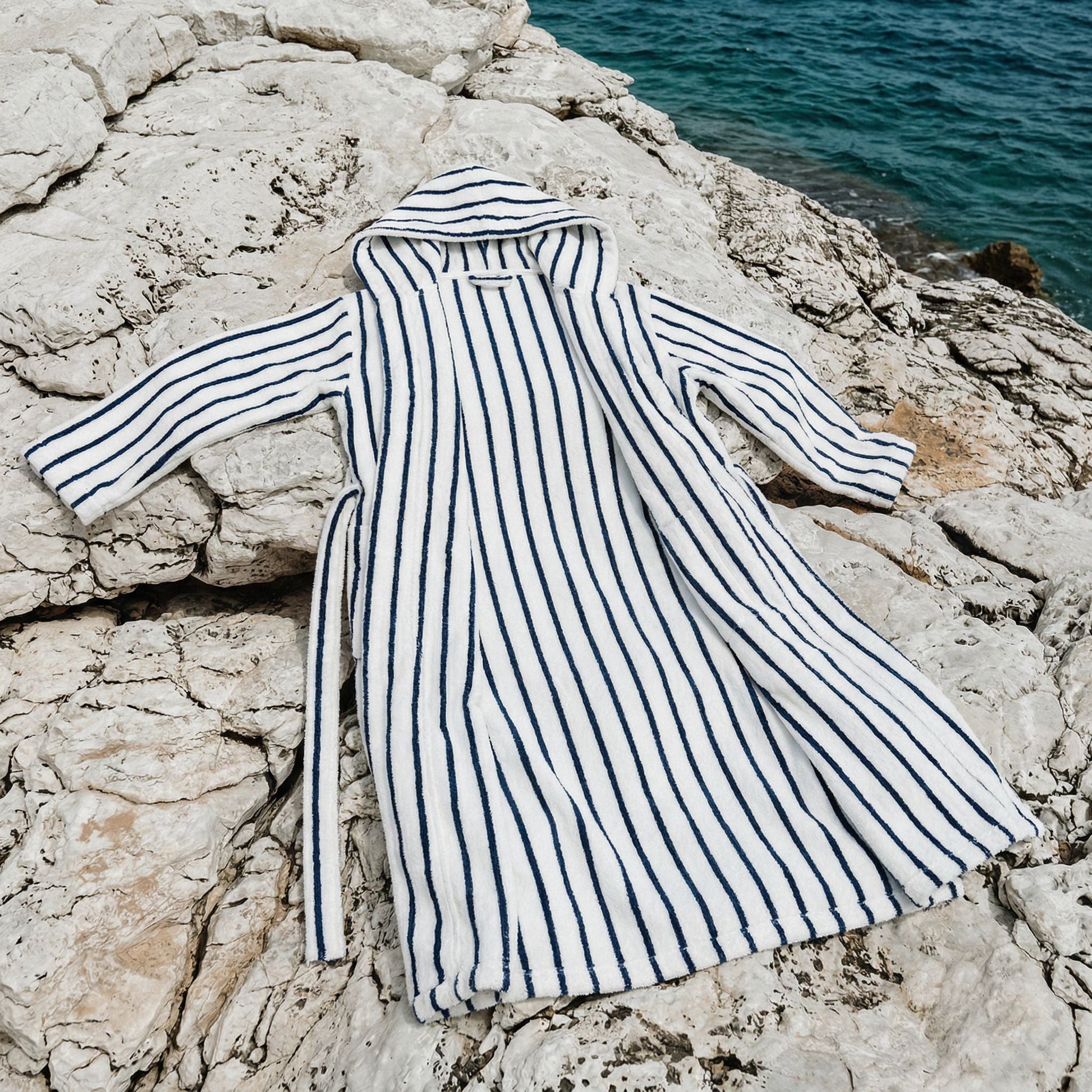 Striped robe on a rocky surface with water in the background