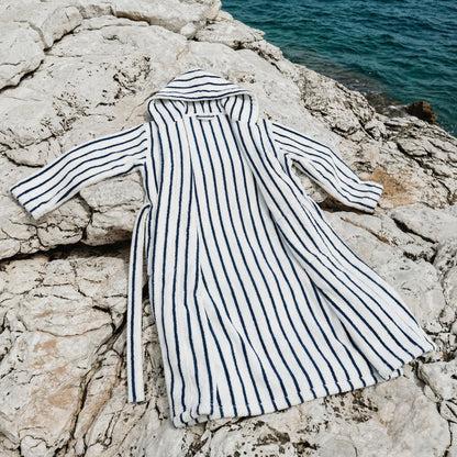 Striped robe on a rocky surface with water in the background