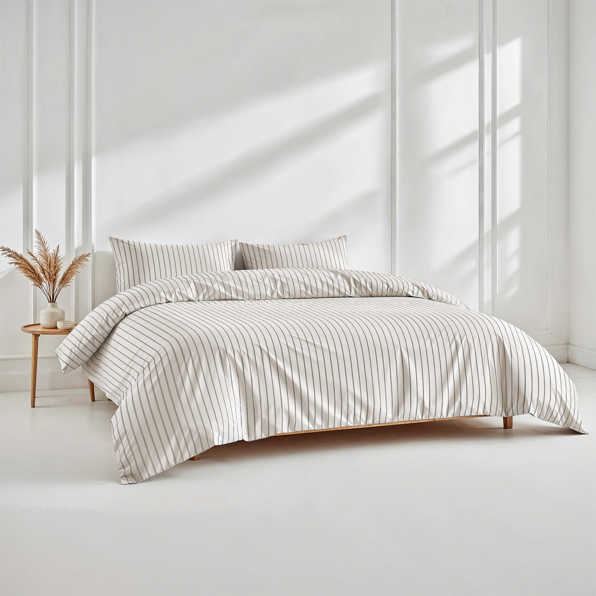 Bed with striped bedding in a bright, minimalistic room