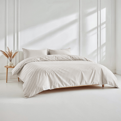 Bed with striped bedding in a bright, minimalistic room