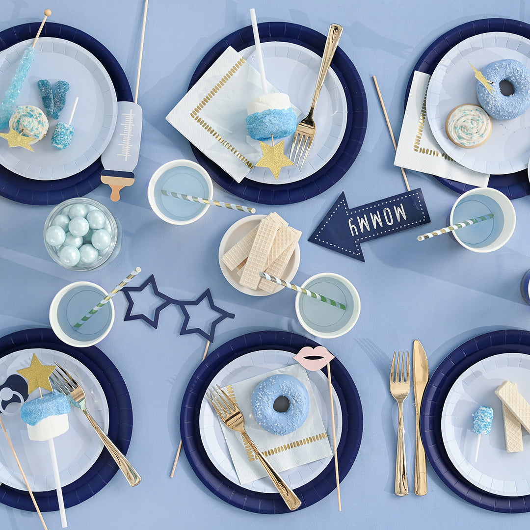 Blue theme party table featuring props for new baby boy.