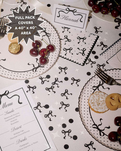 Decorative table setting with black and white patterns on a white tablecloth.