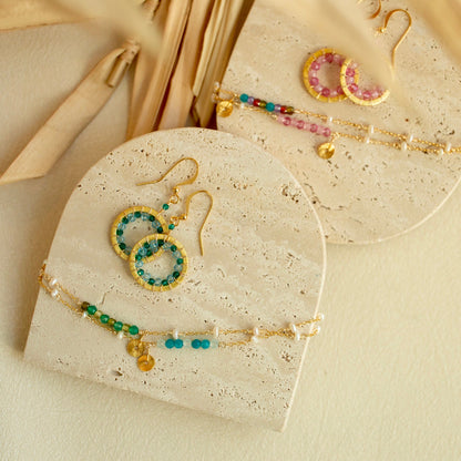 Jewelry set including earrings and a bracelet on a beige surface