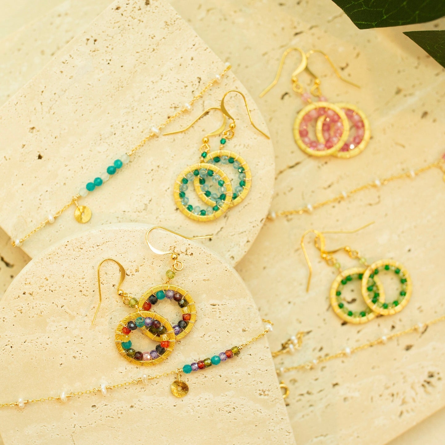 Colorful beaded earrings on a textured beige surface