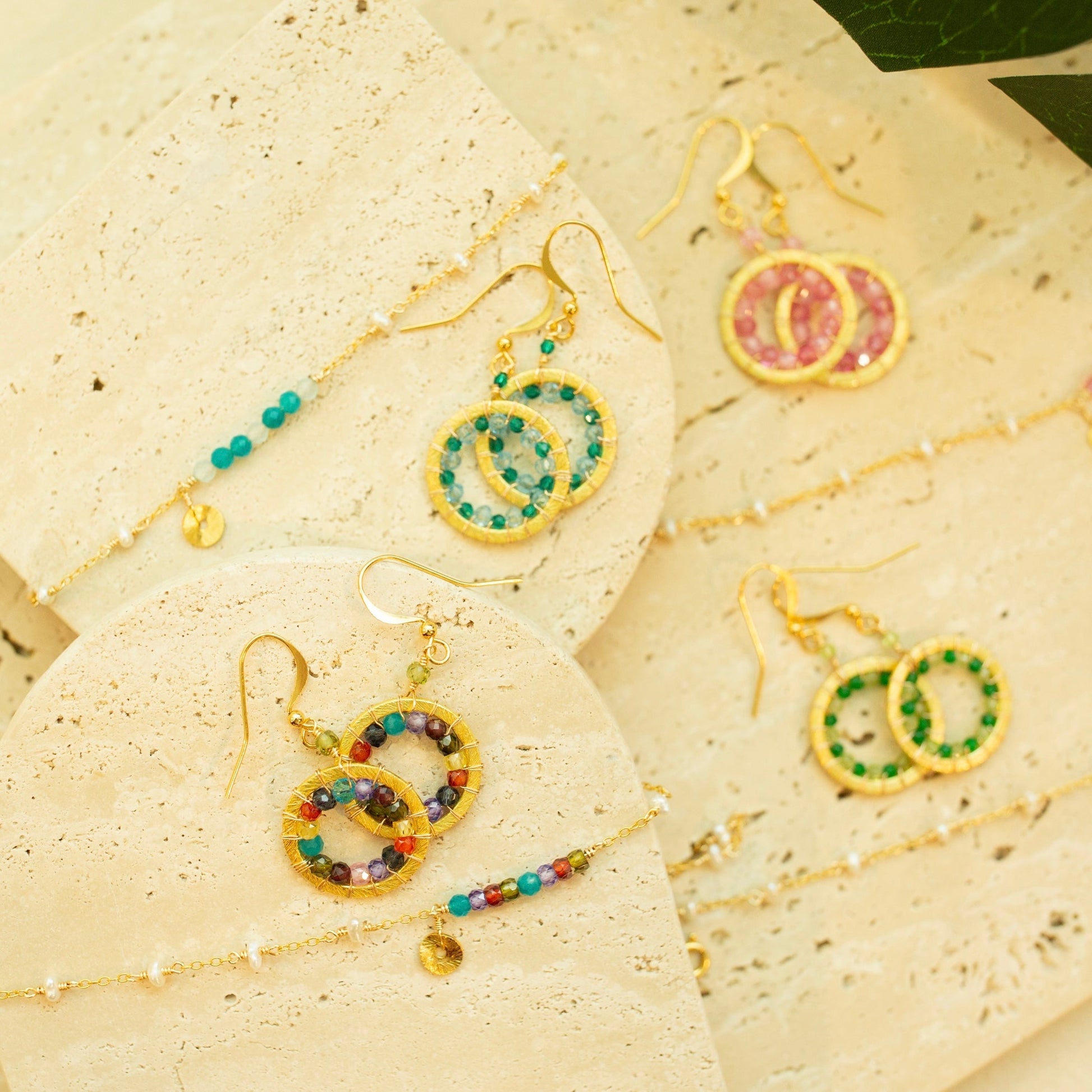 Colorful beaded earrings on a textured beige surface