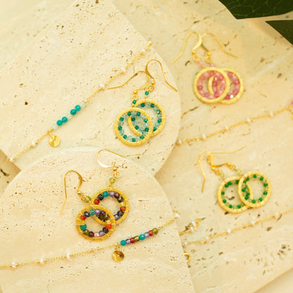 Colorful beaded earrings on a textured beige surface