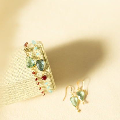 Jewelry set with gemstone earrings on a beige fabric background