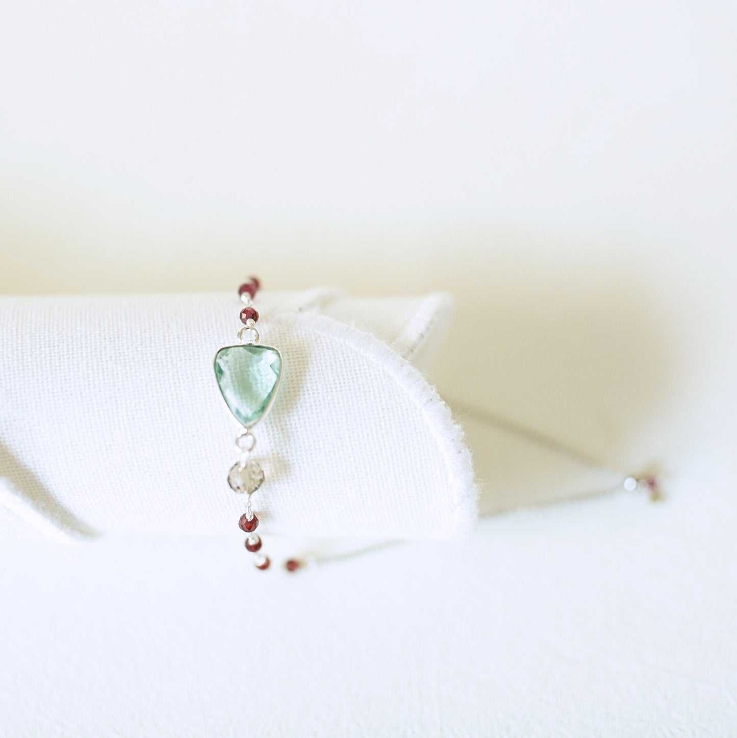 Necklace with a green pendant on a white surface