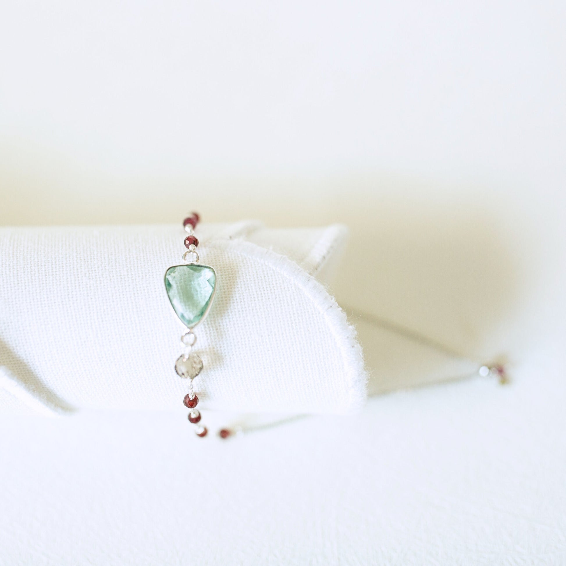 Necklace with a green pendant on a white surface