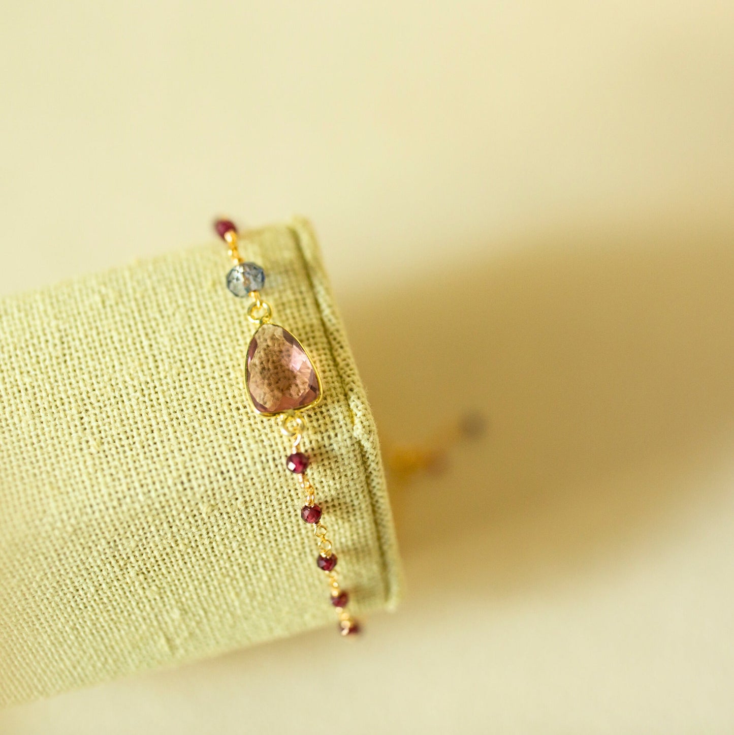 Bracelet with a large brown bead and smaller red beads on a yellow fabric background