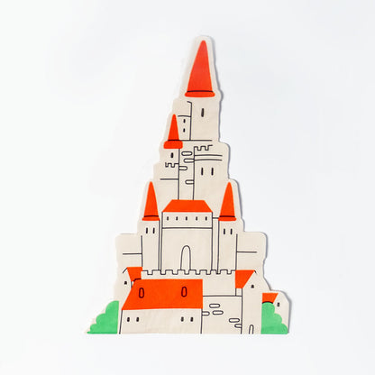 Castle shaped paper napkin with white walls, red pointed roofs, and green bushes at the base.
