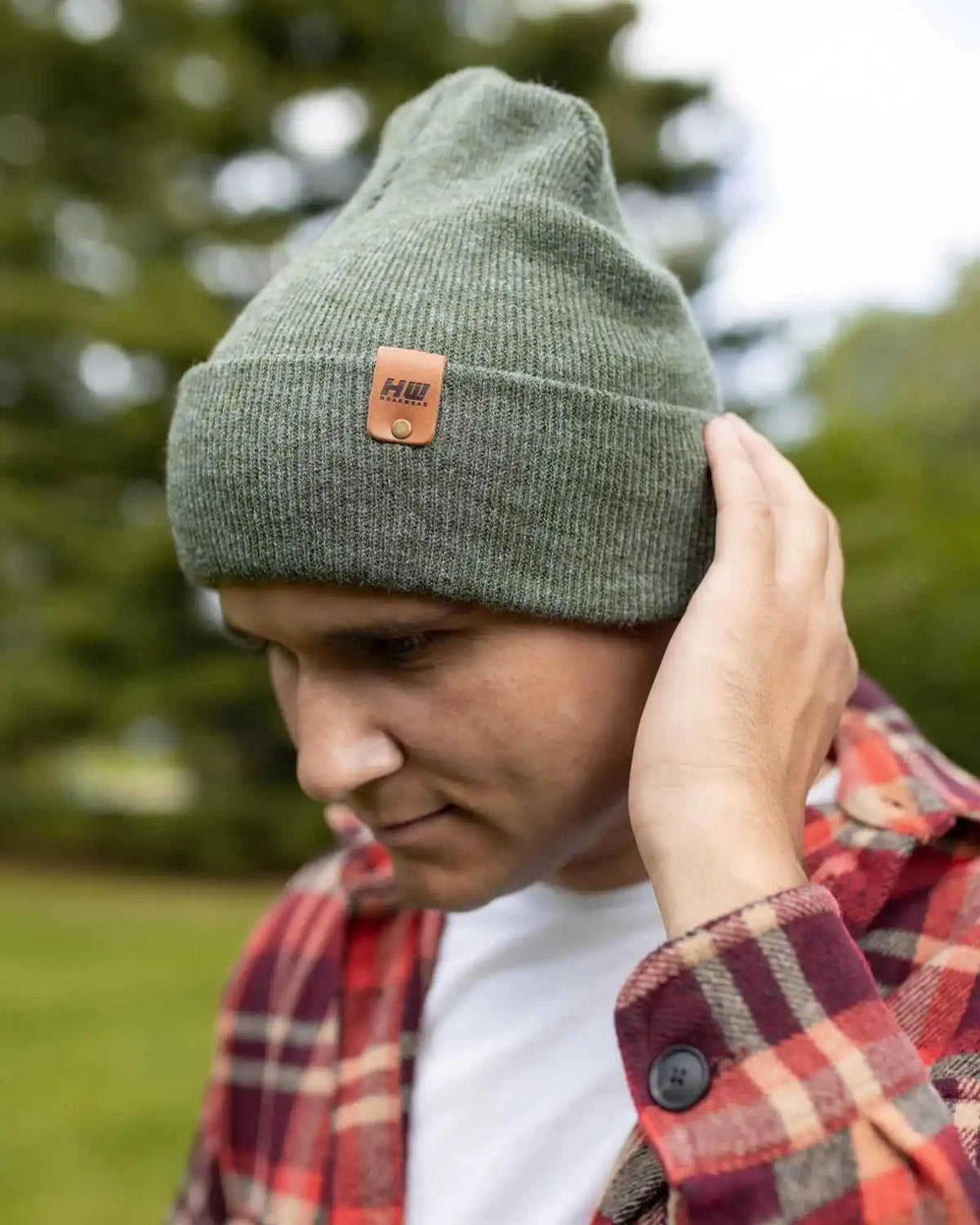 Person wearing a green beanie with a brand logo outdoors