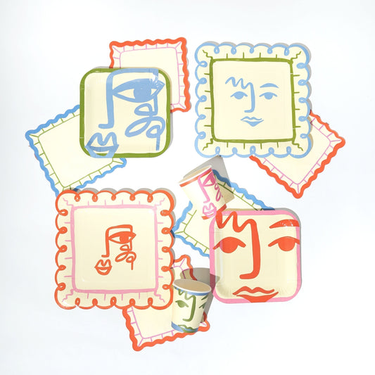 Colorful face-shaped napkins with artistic designs on a white background
