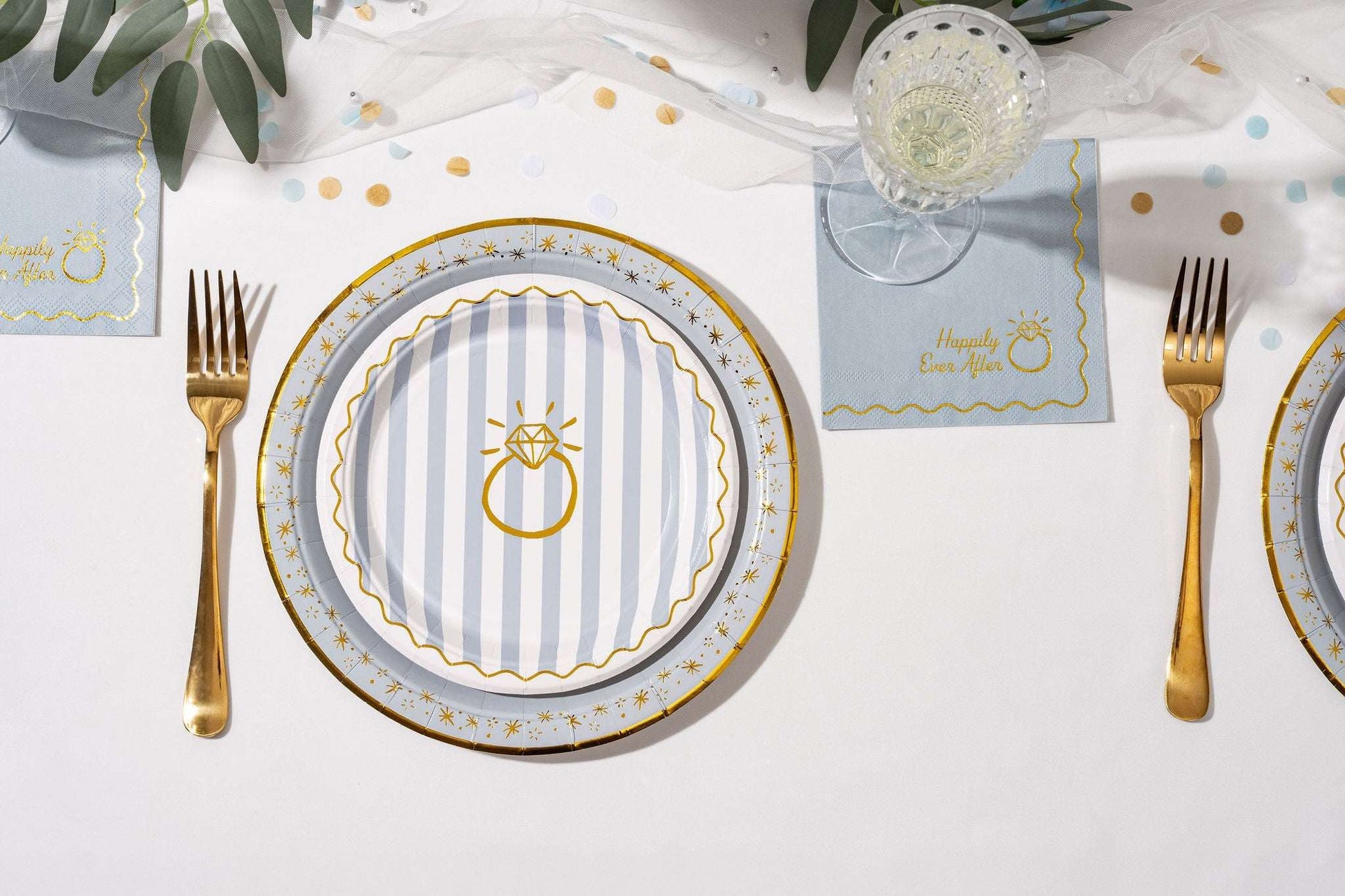 Round blue and white striped paper plate with a gold ring and Happily Ever After text on a matching napkin.