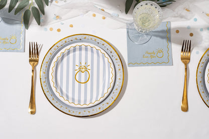 Dinner table setting with plates, cutlery, and place cards on a white tablecloth.