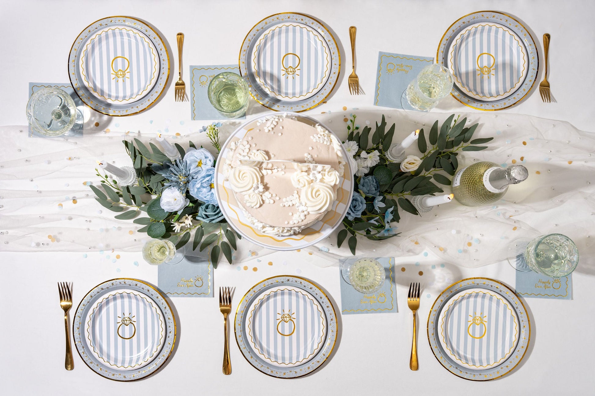 Dinner table setting with plates, cutlery, and place cards on a white tablecloth.