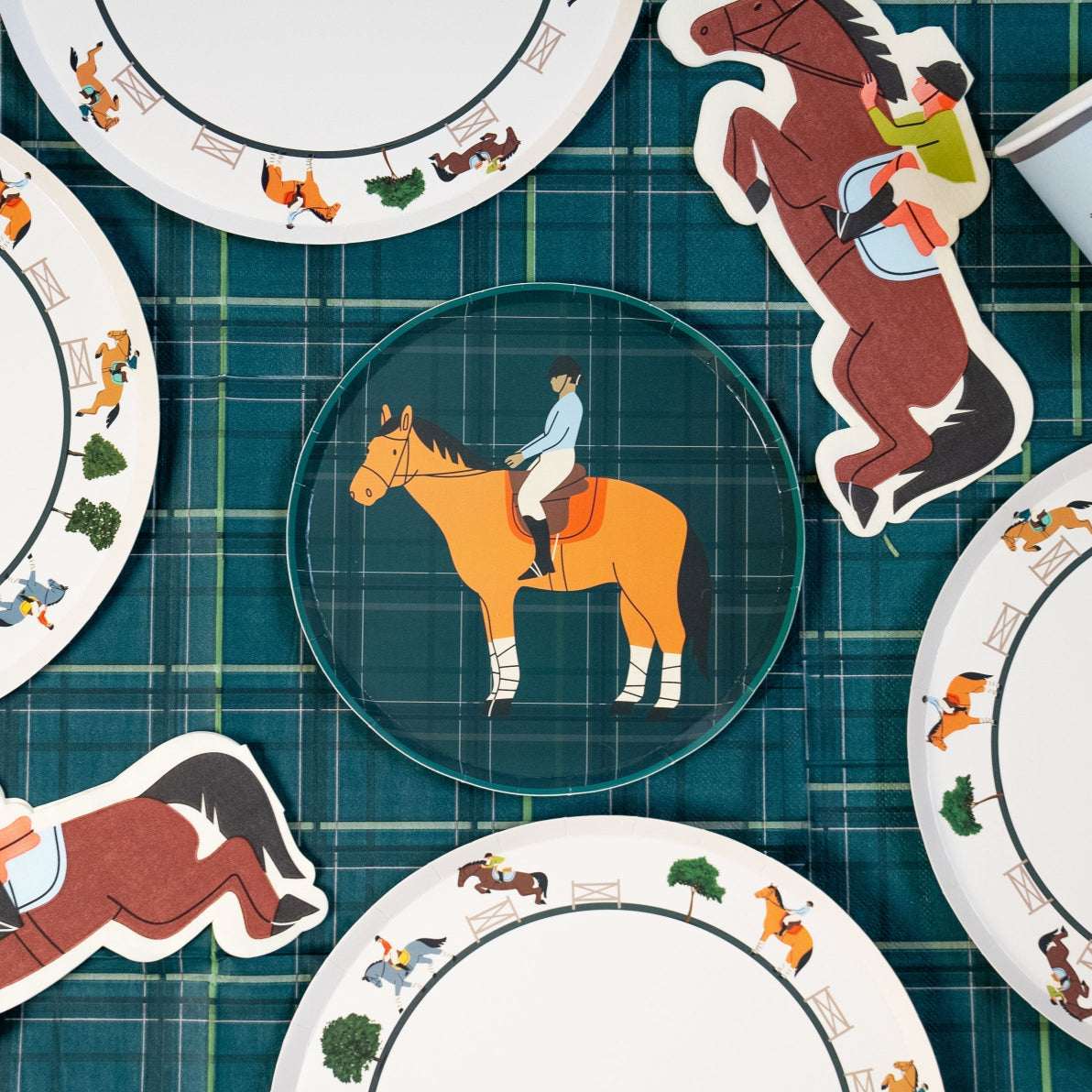 Decorative plates with horse and rider illustrations on a checkered surface