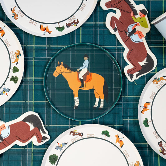 Round paper plates and horse-shaped cutouts featuring equestrian riders on a green plaid background.