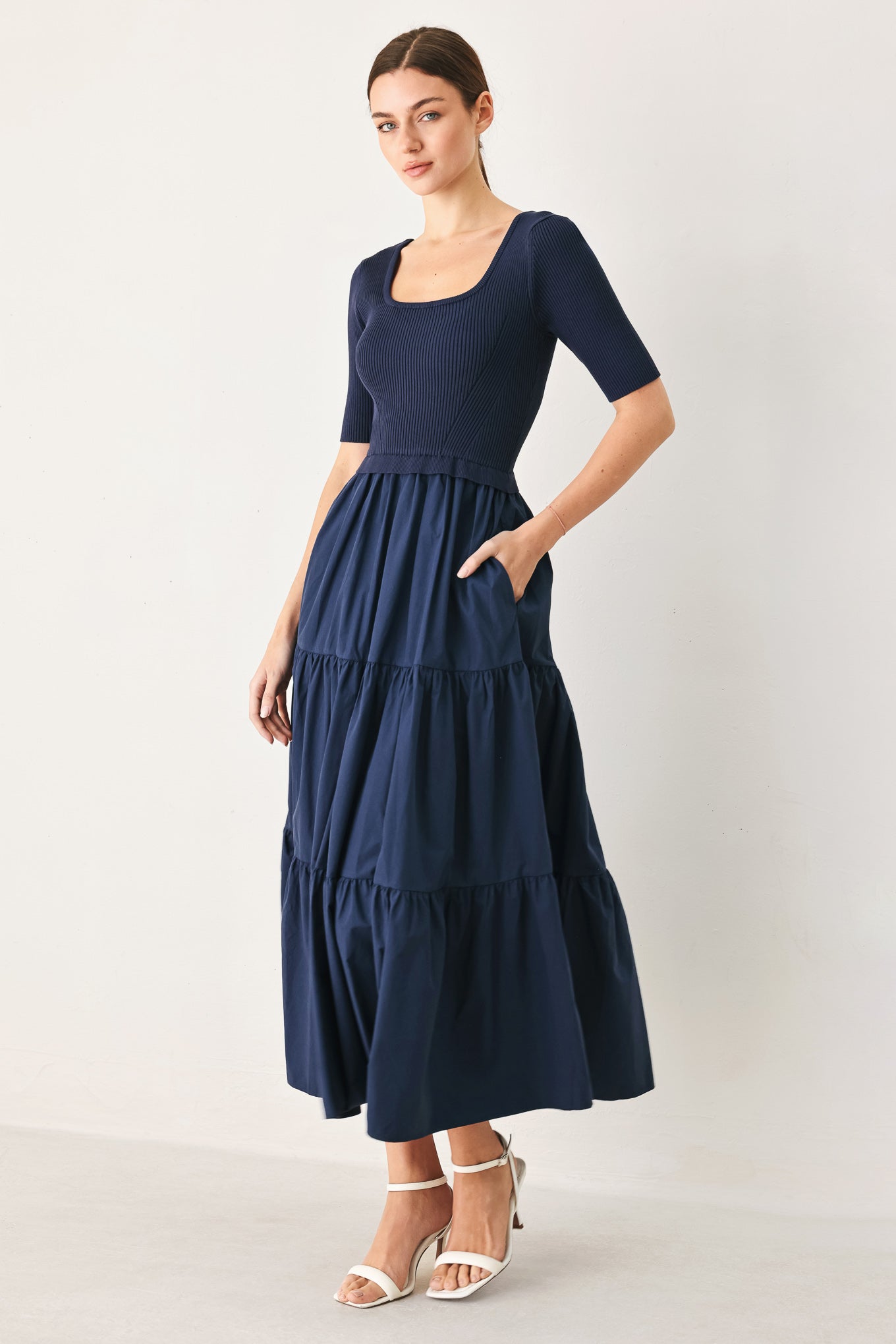 Woman wearing a navy blue dress with a plain background