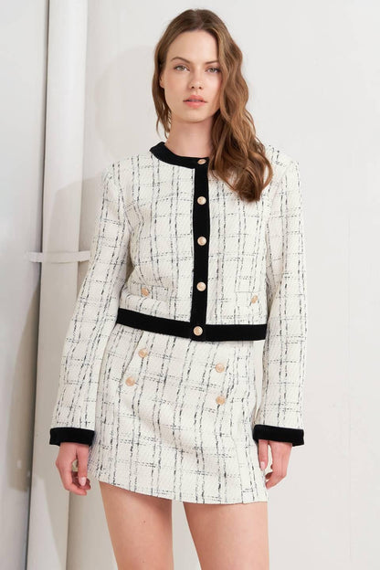 Woman wearing a patterned dress with black accents against a plain background