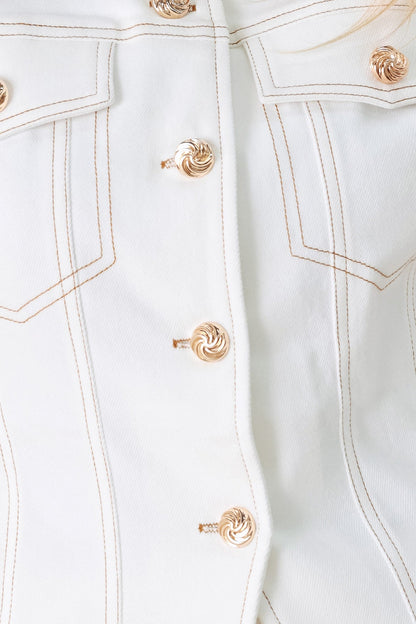Close-up of a light blue denim jacket with gold buttons