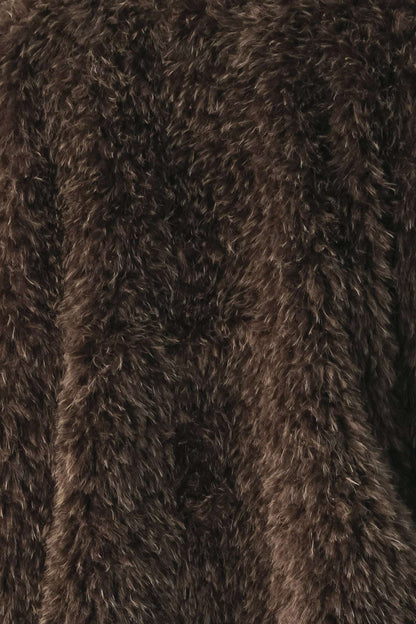 A close-up of dark brown shaggy faux fur fabric texture.